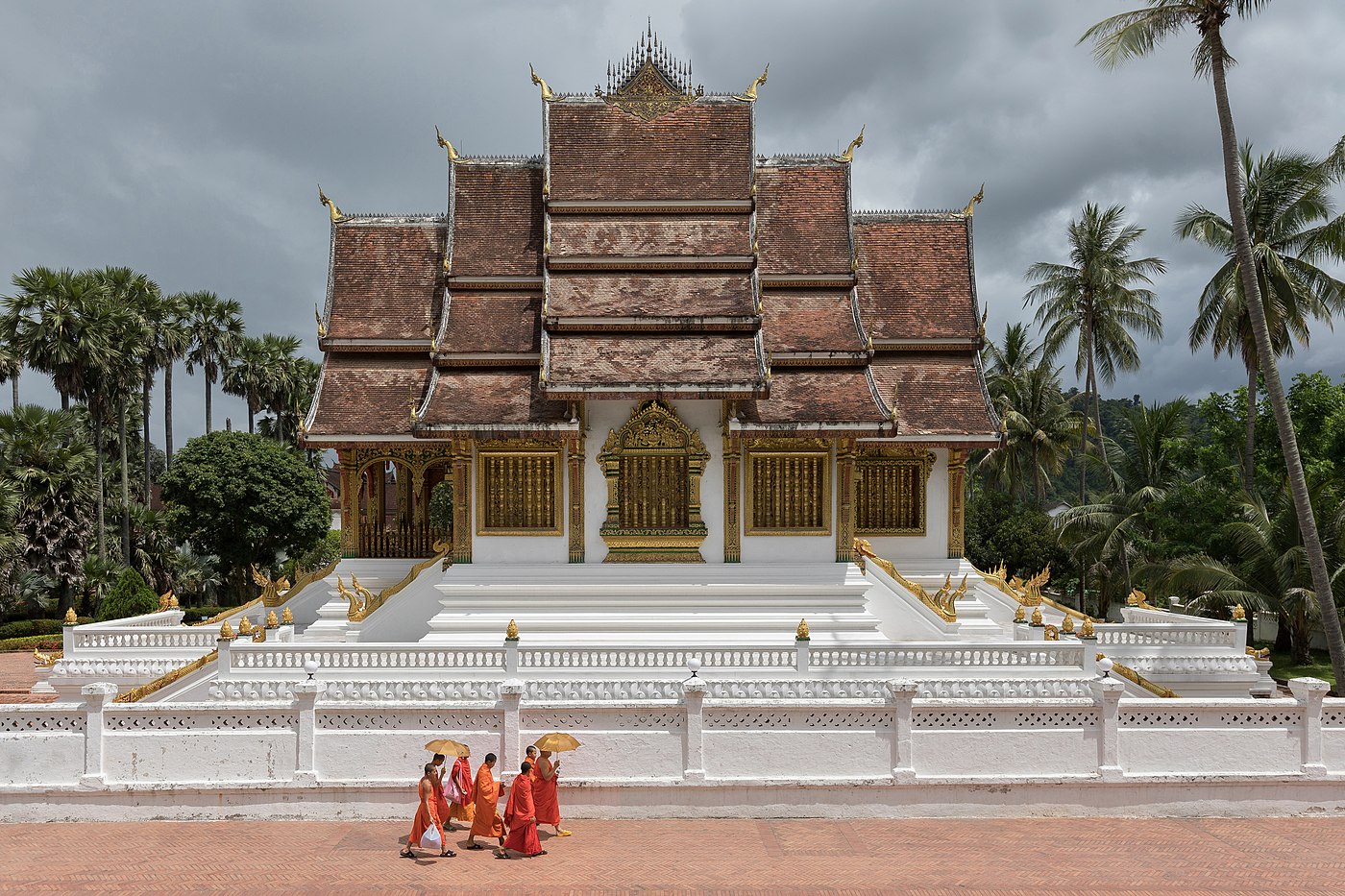 Group of seven Buddhist monks with umbrellas temple Haw Pha Bang Luang Prabang